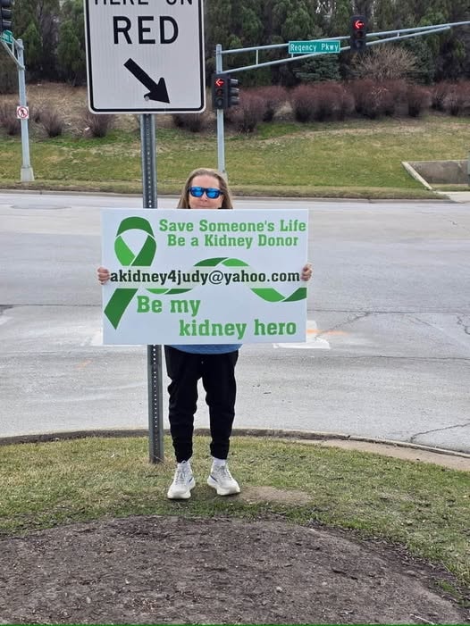 Judy holding a kidney donor awareness sign